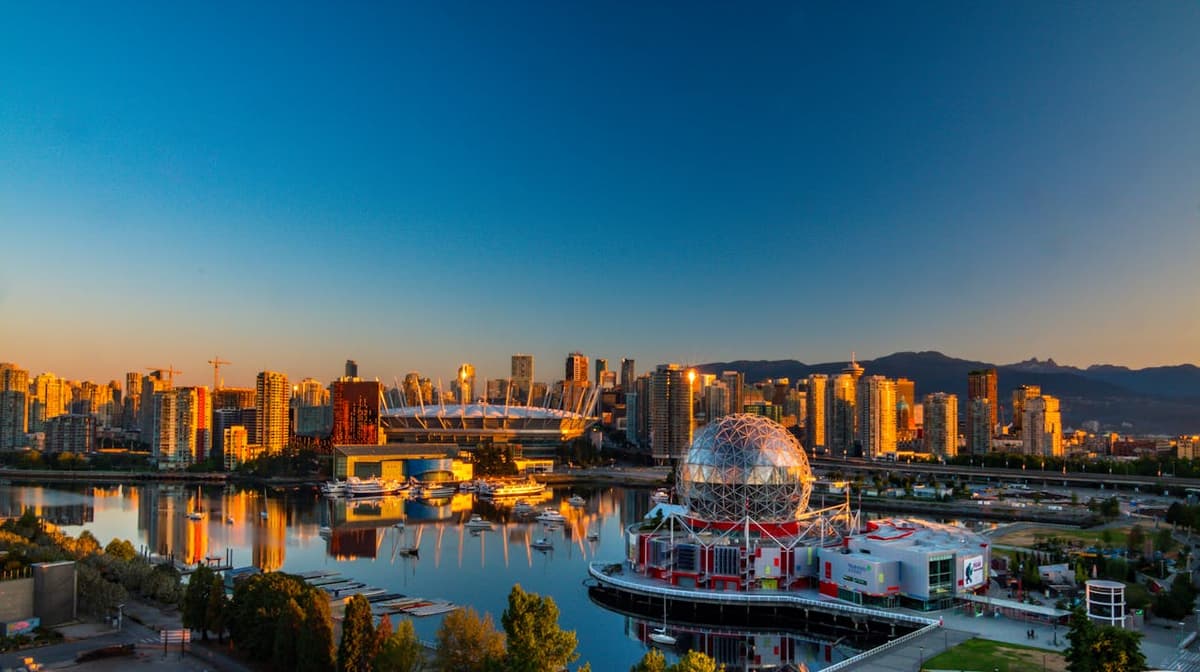 Vancouver skyline at golden hour with mountains and Science World